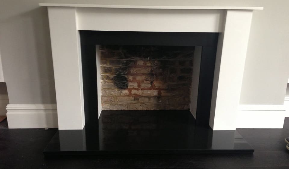 Minimal fireplace design with absolute black granite fire hearth